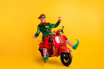 Poster - Portrait of his he nice attractive cheerful cheery ecstatic funny guy elf riding moped having fun fooling rejoicing isolated over bright vivid shine vibrant yellow color background