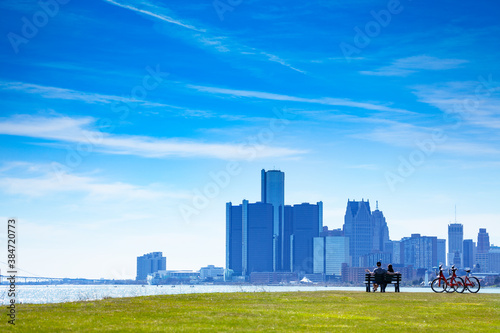 Fotografía Detroit river with view of downtown and lovely couple sit in the bench on Sunset