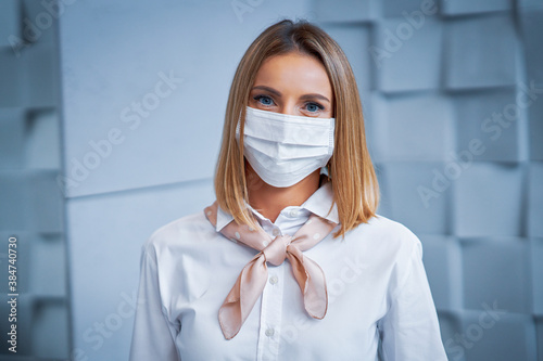 Fototapeta Female receptionist wearing face mask