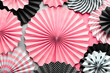 Leinwandbild Motiv Vibrant background with black, pink and white folded paper fans on two tone background.