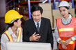 © totojang1977 - Engineer woman and businessman wearing a hardhat standing cargo at goods or merchandise warehouse and check control loading from Cargo freight ship for import and export. Teamwork successful concept.