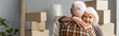© LIGHTFIELD STUDIOS - panoramic shot of senior woman with closed eyes hugging husband in new house, moving concept