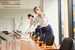 © Seventyfour - Side view portrait of two female secretaries laying out documents while preparing conference room for business event, copy space
