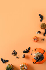 Wall Mural - Halloween banner of fun party decorations, pumpkins, candy bowl, bat, skulls, spider on orange. Top view, flat lay.