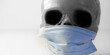 Scary human skull wearing a medical mask, symbolic depiction of death from viral epidemic