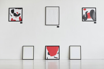 Wall Mural - Graphic background image of modern abstract paintings with black and red hanging on white wall in art gallery exhibition, copy space