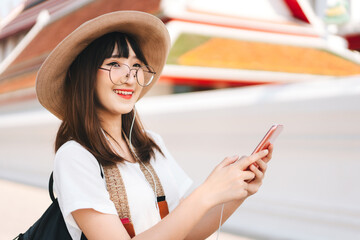 Wall Mural - Young  adult asian woman listen streaming music via smart phone application.