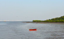 A Little Red Boat Standing In The Middle Of The Water Near Mumbai