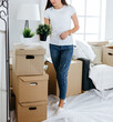 © yurolaitsalbert - happy young woman unpacking boxes in new apartment