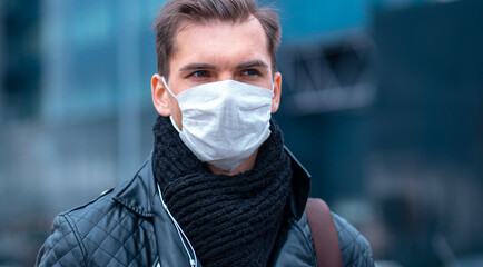 Wall Mural - close up. a man in a protective mask on the background of a city street.