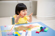 happy Toddler painting water color with her hand. smiley baby girl with painted hand.