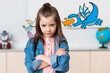 © LIGHTFIELD STUDIOS - Serious schoolgirl looking at camera near birds and dinosaur illustration