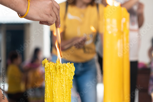 Cuadros en Lienzo Lighting the candle pray to Buddha, big candle and Flame lit by