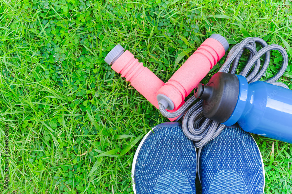 Jump rope, Running shoes, and drink bottle on grass background - obrazy, fototapety, plakaty 