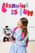 © LIGHTFIELD STUDIOS - Schoolgirl holding robot near learning is fun illustration