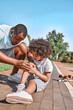 © Afshar Tetyana - Caring father comforting his son after a scateboard incident