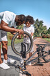 © Afshar Tetyana - Afro-American family of father and son fixing a bicycle