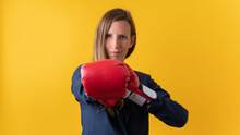 Confident Young Businesswoman Wearing Red Boxing Gloves Punching Towards The Camera