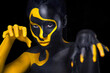 © Mike Orlov - Face art. Woman with black and yellow body paint. Young african girl with colorful bodypaint. An amazing model with yellow makeup. Closeup face.