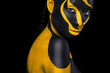 © Mike Orlov - Face art. Woman with black and yellow body paint. Young african girl with colorful bodypaint. An amazing model with yellow makeup. Closeup face.