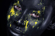 © Mike Orlov - Woman with black body paint. Cheerful young african girl with art bodypaint. An amazing model with yellow makeup. Closeup face.