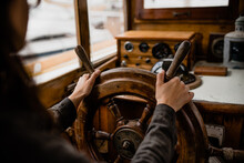 Woman's Hands Steering A Boat Wheel