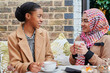© IVAN GENER/Stocksy - Young Muslim friends talking at a cafe