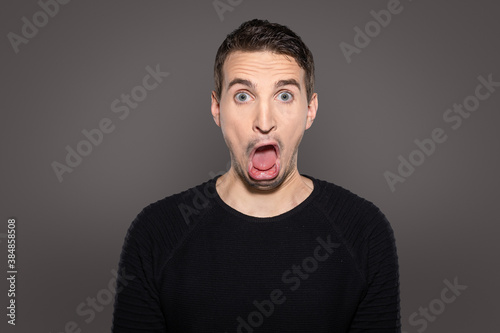 Cuadros en Lienzo grotesque face with open mouth of an adult man isolated on grey background