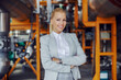 © Dusan Petkovic - Attractive confident independent businesswoman in suit standing in heating plant with arms crossed.