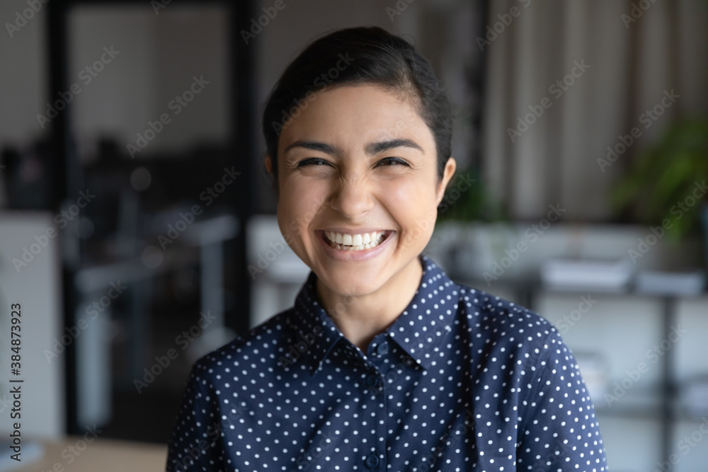 Profile picture of smiling millennial indian female employee posing at workplace. Headshot portrait of happy young 20s mixed race ethnicity woman worker show optimism and confidence in office. - obrazy, fototapety, plakaty 
