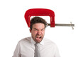 Businessman with a vise on his head. concept of headache