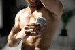 Cropped shot of young handsome man applying deodorant