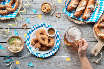 Wall Mural - Celebrating Oktoberfest alone. Traditional food and beer, top view on wooden table,