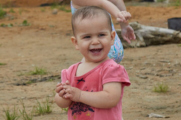 little girl enjoys standing on the sand in the forest