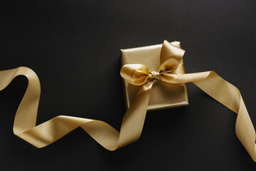 Wall Mural - Golden box with golden ribbon on dark