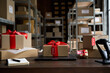 © insta_photos - Table with laptop and gift boxes with sale tags on table in warehouse. Online ecommerce retail business black friday discounts deals, free shipping. Best buy holiday offers concept storage background.