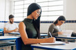 © kleberpicui - Young Brazilian university student sitting at her desk during class.