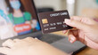 © ChayTee - Close up consumer woman's hand holding credit card making e-bank online payment for purchase in online website store with laptop computer. Ecommerce website payments. new normal digital lifestyle