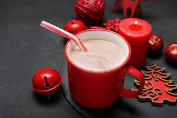 Cup of tasty cocoa drink and Christmas decor on dark background