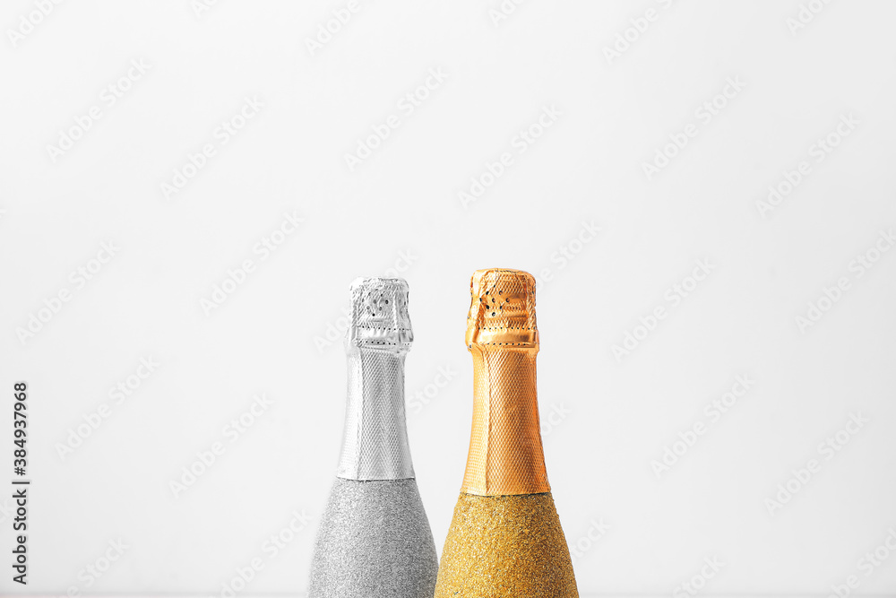 Bottles of champagne on light background