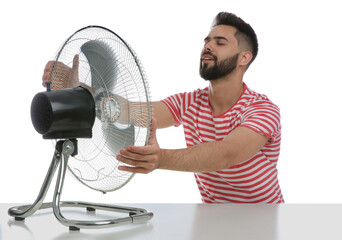 Canvas Print - Man enjoying air flow from fan on white background. Summer heat