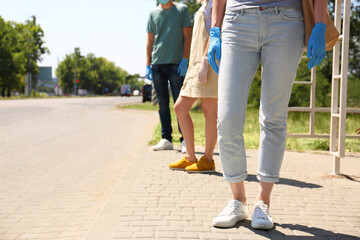 People keeping social distance in line at bus stop, closeup. Coronavirus pandemic