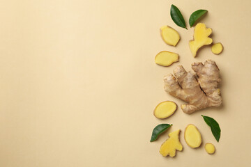 Fresh ginger and leaves on beige background