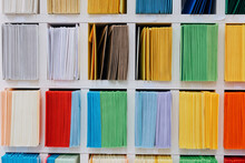 Envelopes Stacks Sorted On A Shelf By Color. Colorful Mail Wraps Arranged In Categories. Large Amount.