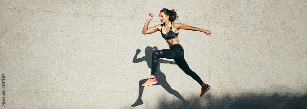 Fit woman jumping and running - obrazy, fototapety, plakaty 