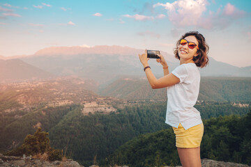 Wall Mural - female travel blogger and social media influencer takes photos against the backdrop of the Taurus mountains in Turkey