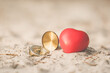 valentine day background. vintage compass and red heart on sand beach