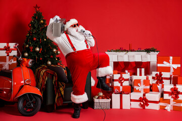 Poster - Full length photo of crazy santa claus in costume hold boom box sing mic song isolated on red color background with x-mas christmas tree