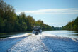Motor boat floating on a forest river, rear view of a Sunny