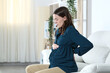 Pregnant woman with back ache complaining at home